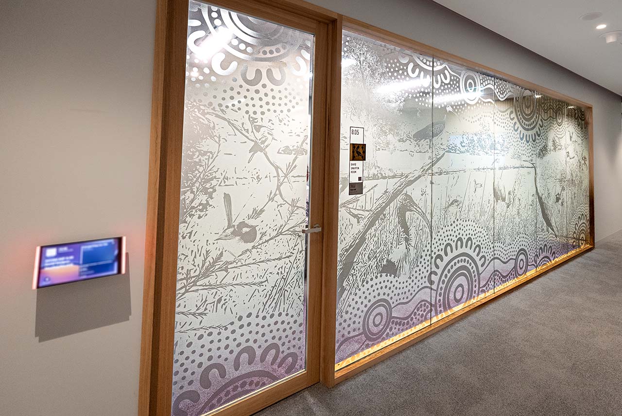 Artwotk on the glass walls of meeting rooms depicting the Lakes/Rivers theme.